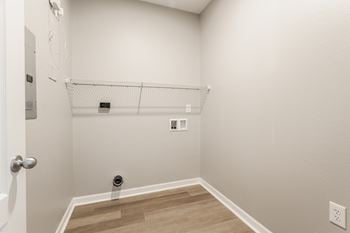An empty closet in a room with wood floors and white walls